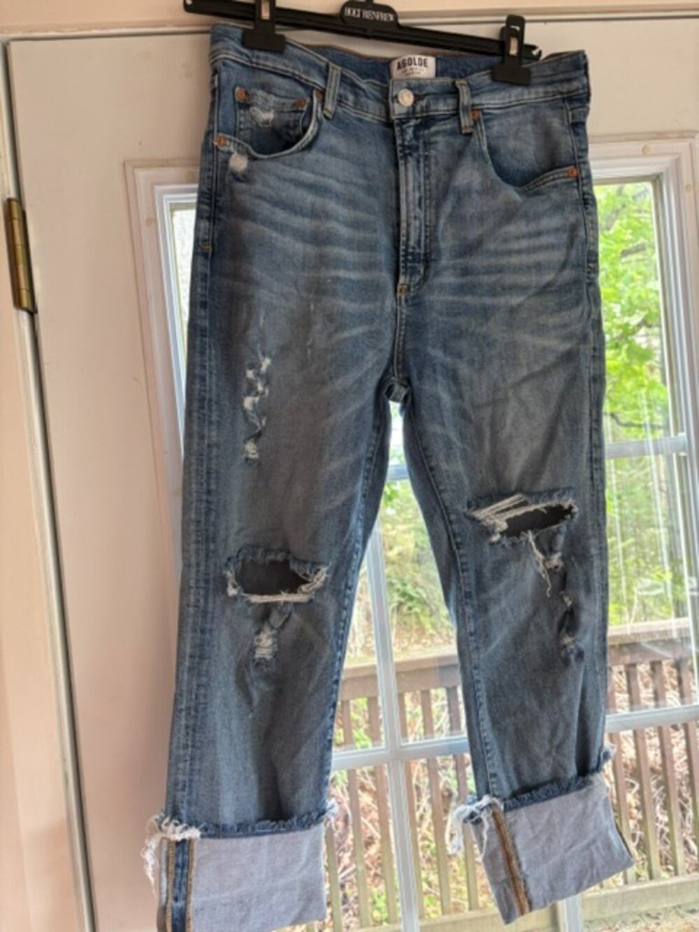 Agolde Size 30 Light wash heavily distressed knees and a raw cuffed hem.